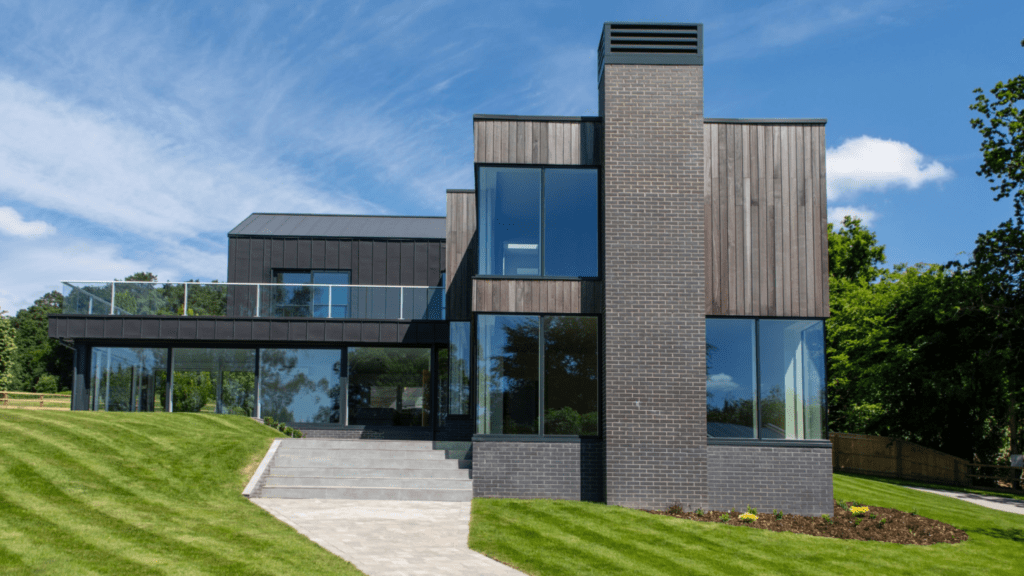 Modern two-storey house with dark wood and brick exterior at The Brac, showing a luxury Passive House timber frame in Wiltshire.